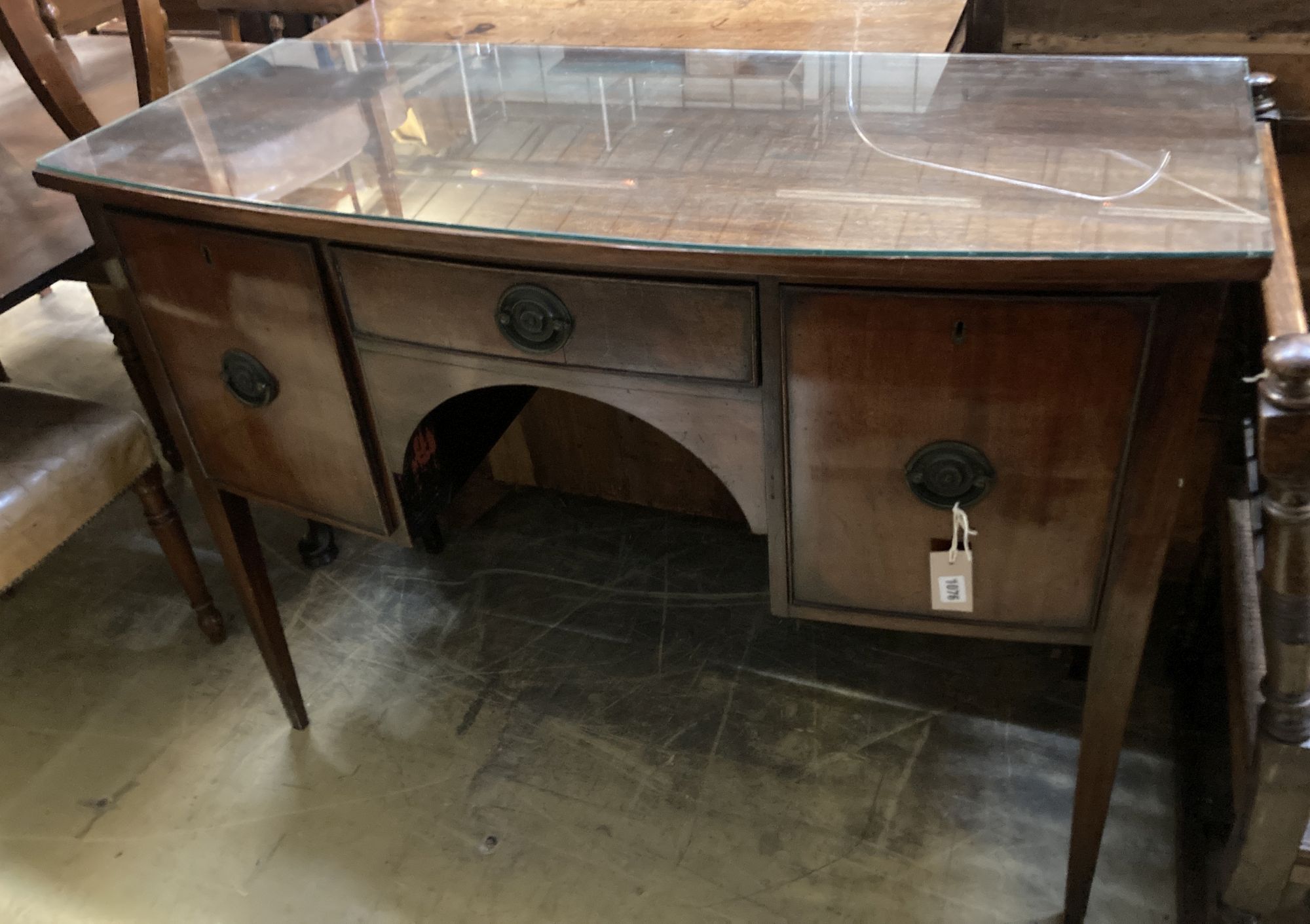 A Georgian mahogany bow front sideboard, fitted with oval brass drop handles, on square tapering supports, length 113cm, depth 48cm, he